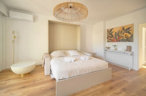 Ein modernes Schlafzimmer mit Bett, Nachttischen, einer Wandablage und einem großen Gemälde.