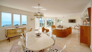 A spacious living room with a large dining table, comfortable seating, and a view of the sea. - 160m2-a C-vue Mer Terrasse Parking A3b132 (Cannes)