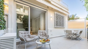 An outdoor patio with two cushioned chairs, a round table with a fruit bowl, and a dining set. - 2 Chambres-terrasse-pointe Croisette A2b267 (Cannes)