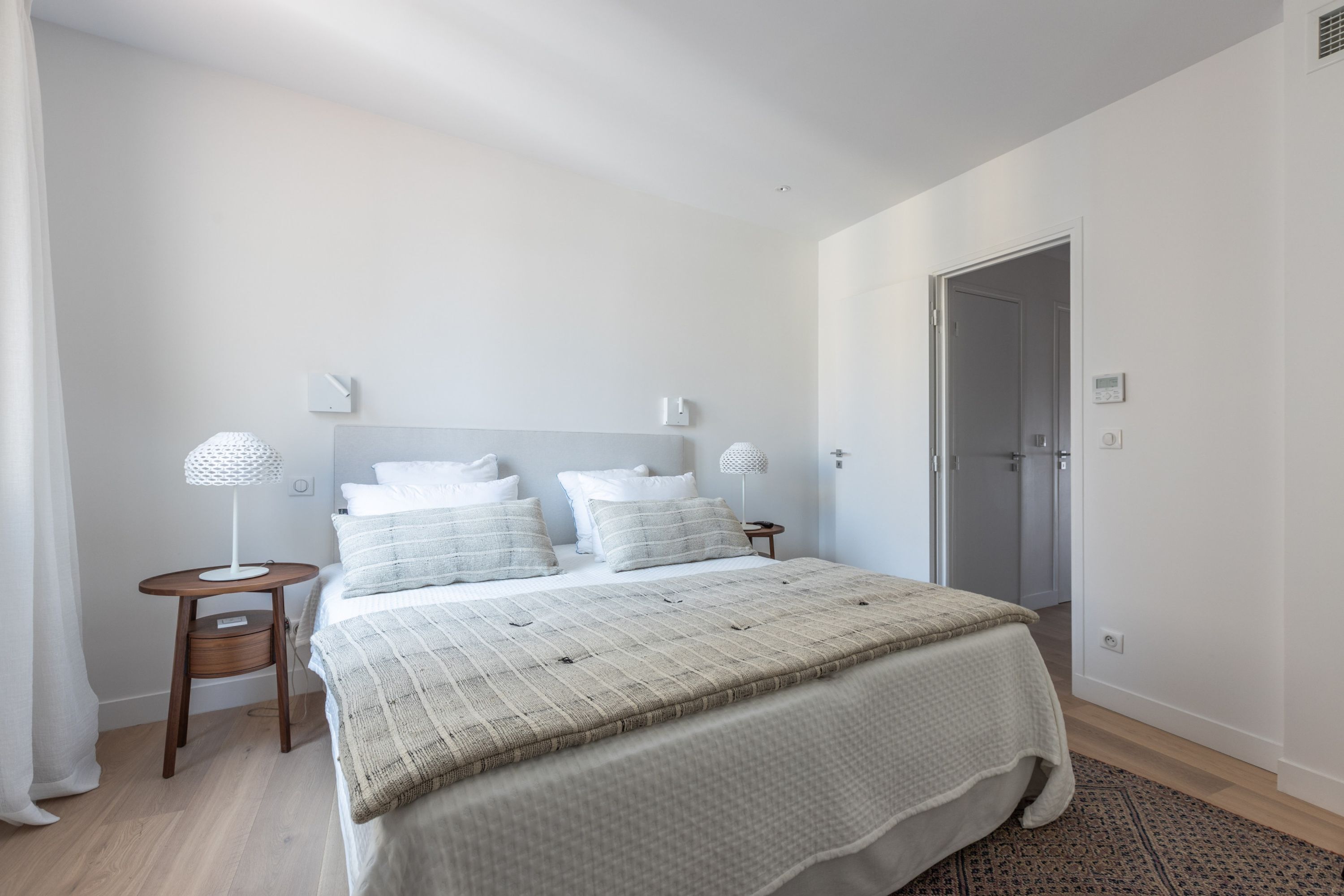 Une chambre à coucher avec un grand lit, deux tables de chevet et une porte.