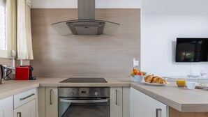 A modern kitchen with a built-in oven, a glass cooktop, and a stainless steel range hood. - Ref 685546 in Cannes (Cannes)