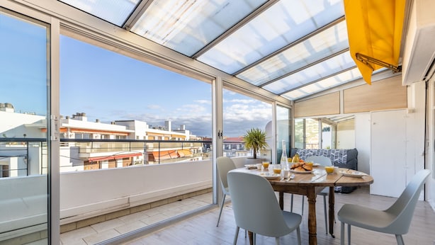 A modern dining area with a glass wall, a wooden table, and four chairs. - Ref 685546 in Cannes (Cannes)