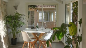 A dining area with a round table, white chairs, and a potted plant. - 3 Chambres Terrasse et 1 Chambre Studio A4b026 (Cannes)