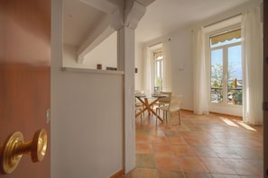 A room with a dining area, a large window with curtains, and a tiled floor. - Joli 2 Pieces VUE MER A1b271 (Cannes)