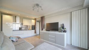 A modern living room with a sofa, a flat-screen TV, and a kitchen in the background. - Ref 670723 in Cannes (Cannes)