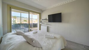 A hotel room with a large bed, a TV mounted on the wall, and a view of the city through the window. - Ref 670723 in Cannes (Cannes)