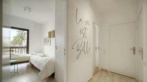 Ein Hotelzimmer mit einem Bett, einem kleinen Tisch und einer Wand mit einem französischen Spruch.