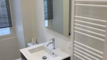 Regadera, secadora de cabello, toallas, papel de baño