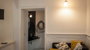 A room with a bed, a bedside table, a wall-mounted light, and a door leading to a bathroom. - Intrà residenza in trastevere (Rome)