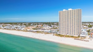 Un hôtel de grande hauteur offrant une vue sur la plage, doté de nombreux balcons et situé en bord de mer.