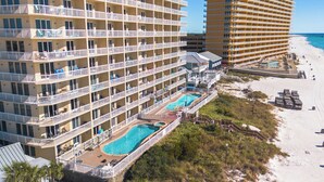Un hôtel à plusieurs étages doté de balcons, d’un espace piscine et offrant une vue sur la plage.