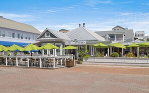 A restaurant with outdoor seating and green umbrellas. - Son Worshipers - Seaside Home near Iconic Town Council! (Santa Rosa Beach)