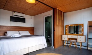 A bedroom with a bed, a vanity with a mirror, and a shower area. - House w/ BBQ and Lake Access Mat0021 (Garopaba)