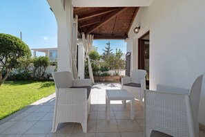 An outdoor patio with white wicker furniture and a tiled floor. - Holiday Home 'Fiorita' with Wi-Fi and Air Conditioning (Budoni)