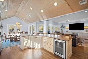 Una cucina spaziosa con mobili in legno, una grande isola centrale e un forno integrato.