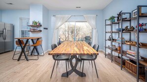 Una cocina moderna con una mesa de comedor de madera, sillas y una estantería empotrada.