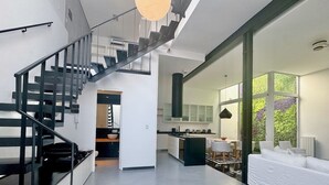 Un intérieur moderne comprenant un escalier, une cuisine et un espace de vie.