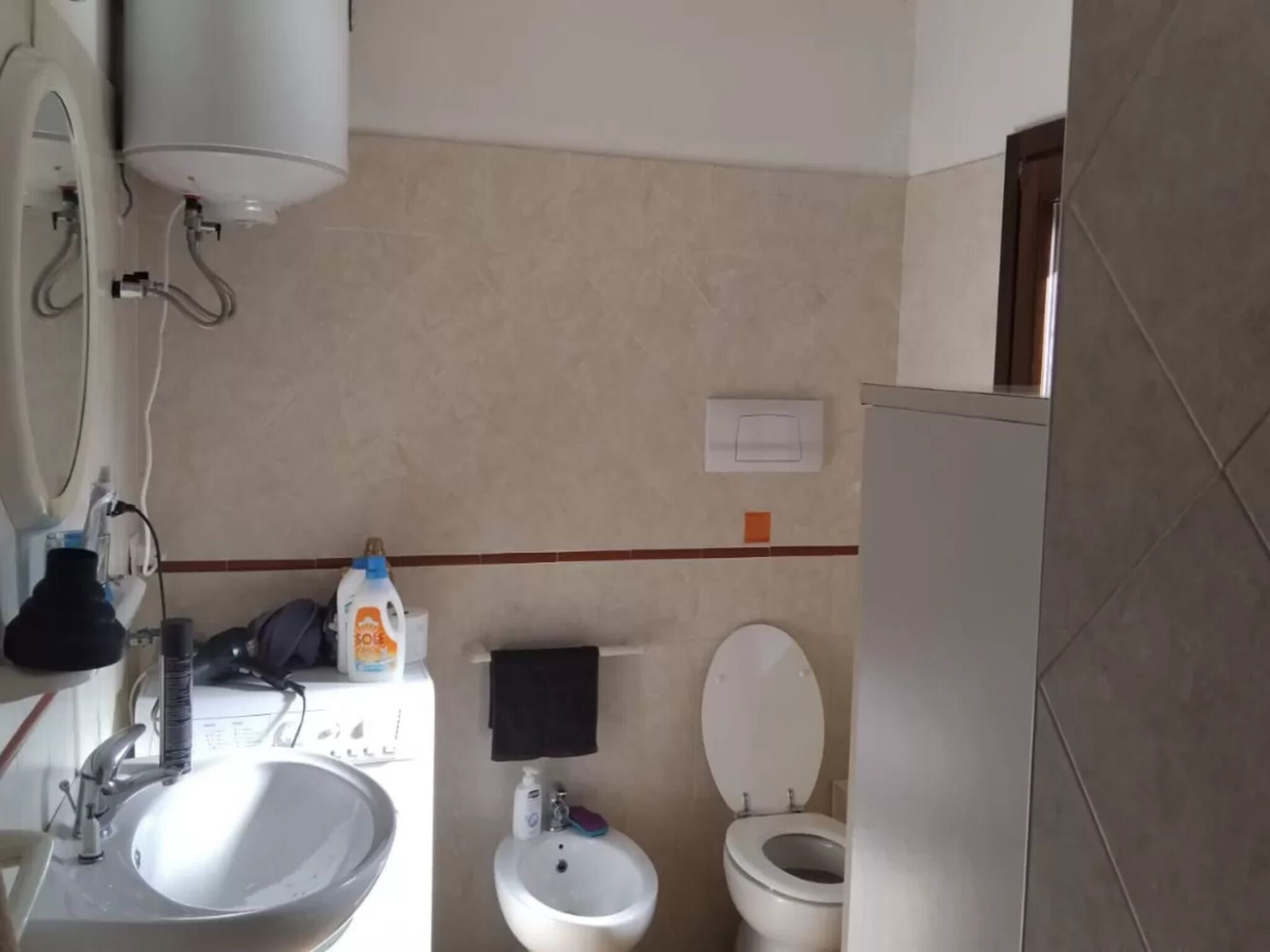 A bathroom with a sink, bidet, toilet, and a mirror.