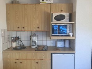 A compact kitchen with wooden cabinets, a Bosch coffee maker, a microwave, a toaster, and a dishwasher. - 2-room apartment for 4, at the slopes, parking included (Combloux)