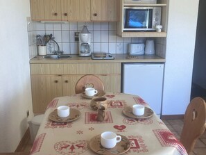 A small kitchenette with a microwave, coffee maker, and toaster. There is a table with a tablecloth and several cups and saucers. - 2-room apartment for 4, at the slopes, parking included (Combloux)