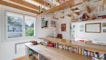 Une cuisine dotée de plans de travail en bois, d’une fenêtre offrant une belle vue et de divers ustensiles de cuisine.