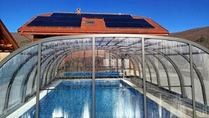 A transparent greenhouse structure with a pool inside.