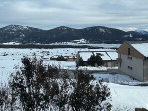 A snow-covered landscape with a building featuring a sloped roof and a small tower. - Les Angles - Cozy T2 Cabin 4 Pers (Les Angles)