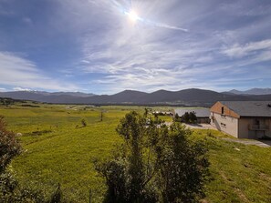 A rural landscape with a house, open fields, and mountains in the background. - Les Angles - Cozy T2 Cabin 4 Pers (Les Angles)