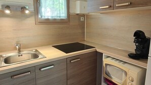 A compact kitchen with a sink, a microwave, and a coffee maker. - Cozy Chalet for 5 with Terrace (Montlaur)