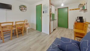 A compact living space with a dining area, kitchenette, and a sofa. - Apartment in Les Rousses with Terrace (Les Rousses)