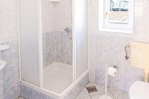 A bathroom with a shower, toilet, and sink. - Cozy Apartment for 5 near the Sea (Povljana)