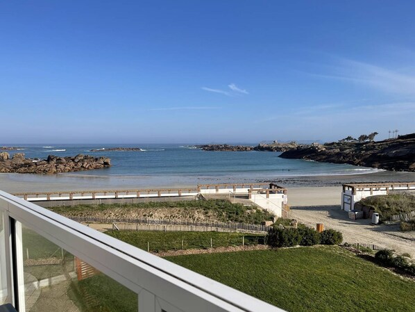 A coastal view with a rocky shoreline, a wooden walkway, and a grassy area. - Sea View Apt, WIFI, Parking for 2 in Trégastel (Trégastel)