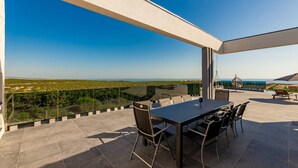 Une terrasse avec une table et des chaises, offrant une vue sur un paysage magnifique.