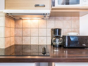 Eine Küche mit einer eingebauten Mikrowelle, einer Kaffeemaschine und einem Toaster auf der Arbeitsfläche.