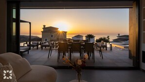 A modern interior with a large glass door leading to a terrace with a sunset view. - Villa CARRERA by Abahana Villas (Benitachell)