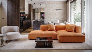 Ein modernes Wohnzimmer mit einer Eckcouch, einem Couchtisch und einem Essbereich mit Stühlen.