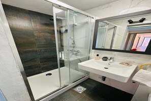 A modern bathroom with a glass-enclosed shower, a white sink, and a large mirror. - Stylish Couple Getaway Near Beach (Sukošan)