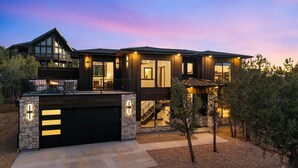 A modern two-story house with a garage, large windows, and a stone facade. - East Zion New Build, Sleeps 12, Hot Tub, Rooftop Fire Pit & Game Room (Orderville)