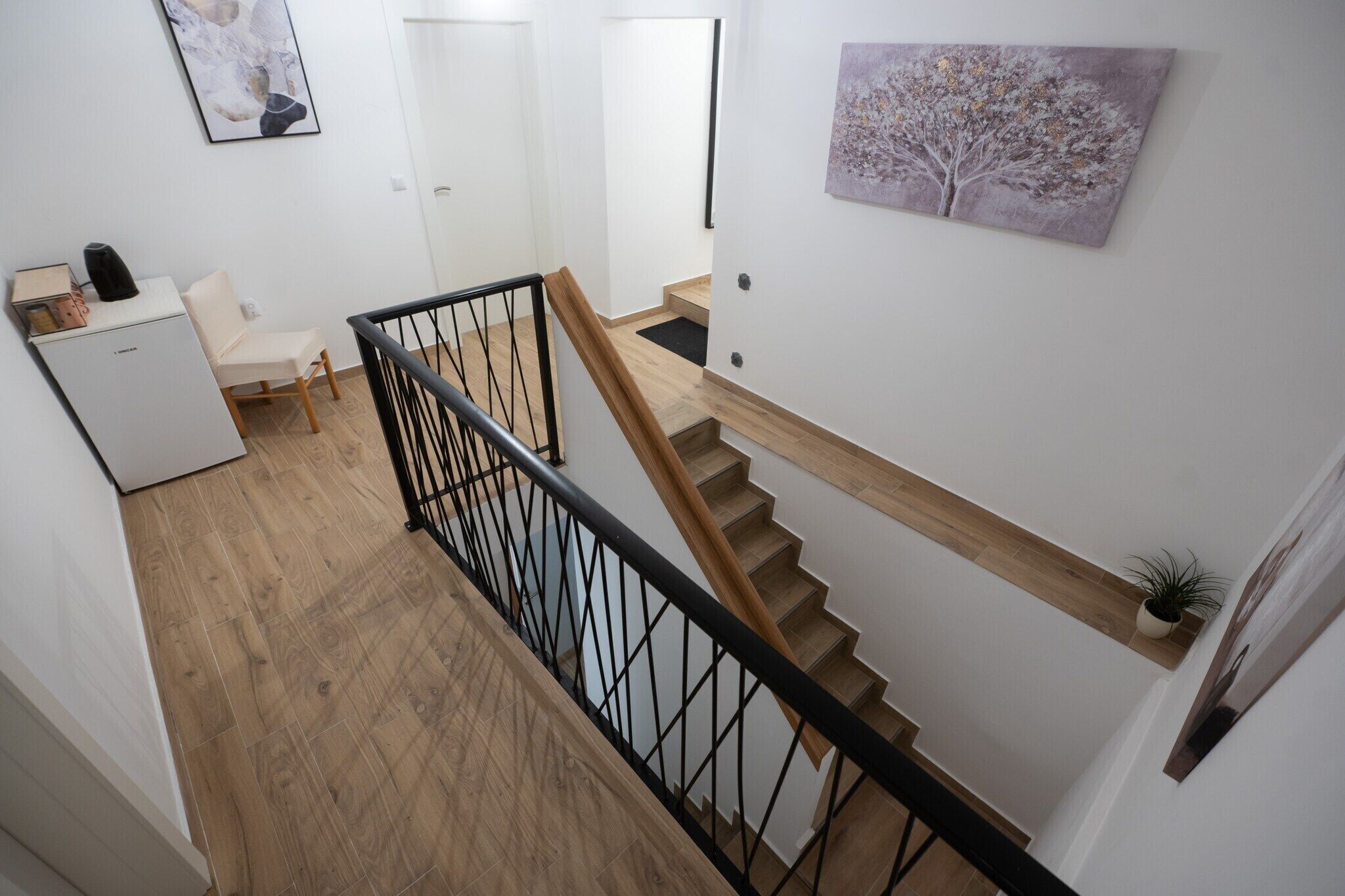 Una escalera con escalones de madera y barandilla de metal negro.