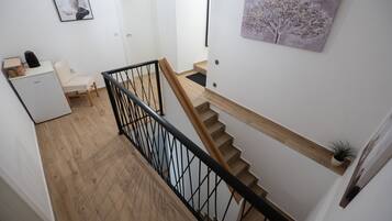 Una escalera con escalones de madera y barandilla de metal negro.