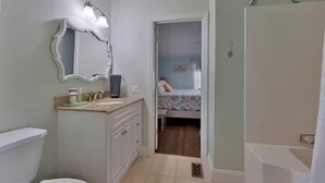 A bathroom with a sink, mirror, and shower. - GOTL Retreat, short walk to strip, 15 min to Spire (Geneva on the Lake)