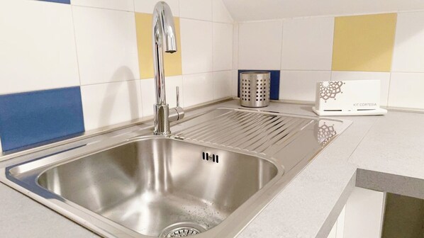 A modern kitchen with a stainless steel sink, a faucet, and a trash can. - Appartamento Sestiere Castello by Ca-Sa Check (Venezia)
