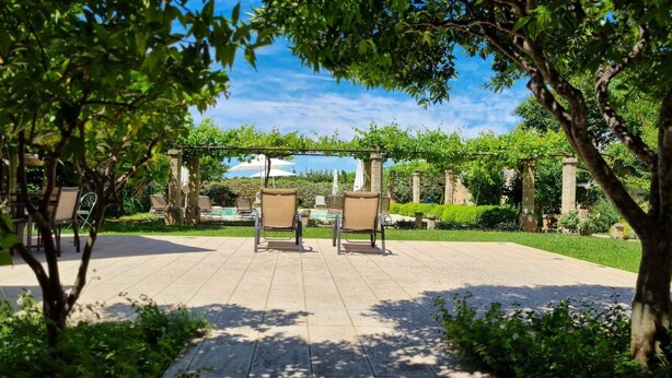 An outdoor patio with two lounge chairs, a pergola, and a pool area. - Altra Meta Palace by LoveSud (Gagliano del Capo)