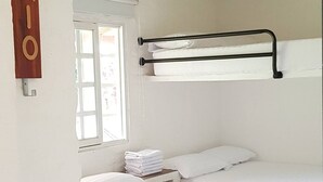 Ein Zimmer mit einem Bett, einem Fenster, einem Handtuchhalter und einem Schild mit dem Wort "RIO".