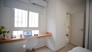 A bedroom with a bed, a desk with a laptop, a chair, and a window. - Home office apartment with a fully equipped, comfortable desk, Roca (General Roca)