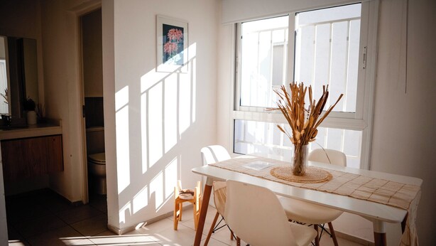 A dining area with a white table, chairs, and a vase with dried plants. - Home office apartment with a fully equipped, comfortable desk, Roca (General Roca)