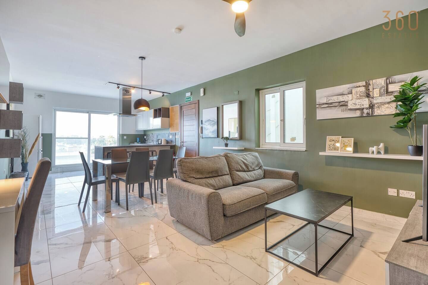 Un salon moderne avec un canapé, une table basse et un coin repas.
