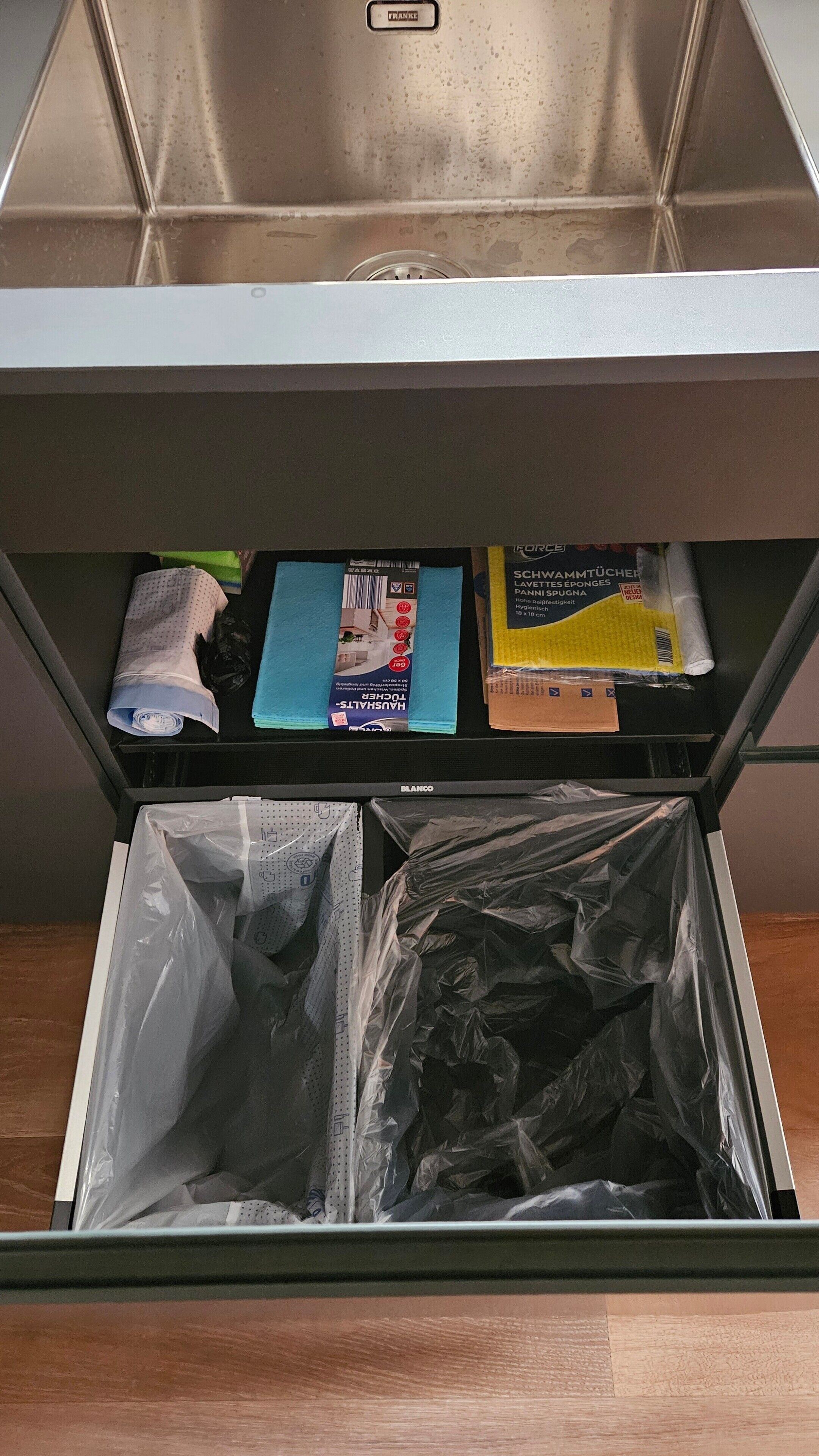 A drawer with various items including a blue box labeled 'HANSHAUS,' a yellow box labeled 'FORCE,' and a white plastic bag.
