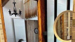Un baño moderno con un mueble de tocador de madera, un espejo redondo y un lavabo blanco.