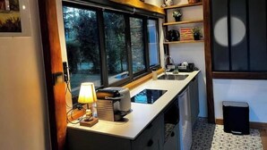 Una cocina compacta con ventana, un lavamanos y una pequeña encimera.